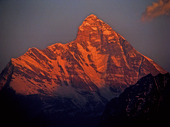 Nandadevi, Indias second tallest peak, glows orange under a setting sun. To reconnect with his homeland after a devastating attack left him traumatised, the author undertook treks to Bandarpoonch, Nandadevi and Mt. Kailash.